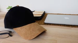 หมวกแก๊ปปีกหมวกหนัง-สีดำ-บนโตีะทำงาน