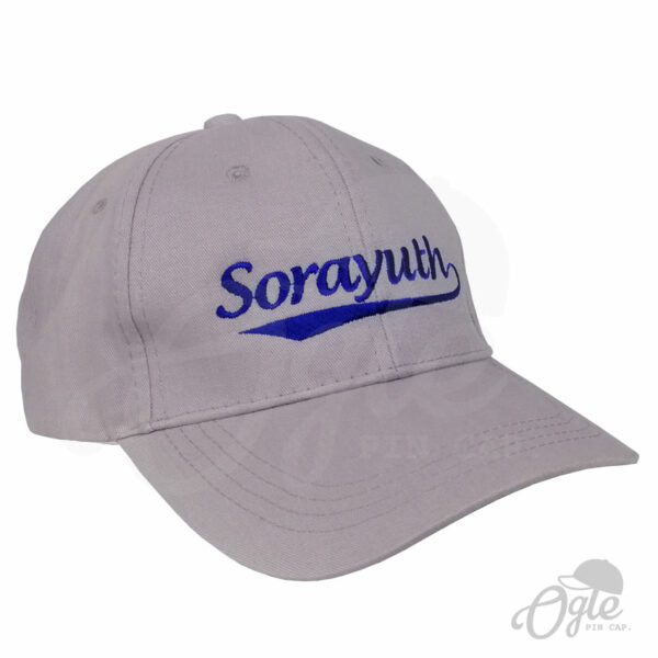 หมวกแก๊ปผ้าพีช-สีเทา-ปักชื่อ-Sorayuth-ไหมปักสีน้ำเงิน-เอียงข้างซ้าย